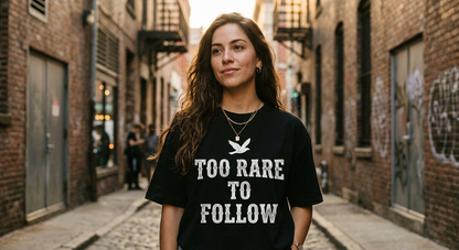 Confident Latina woman in alleyway wearing TOO RARE TO FOLLOW black tee at golden hour
